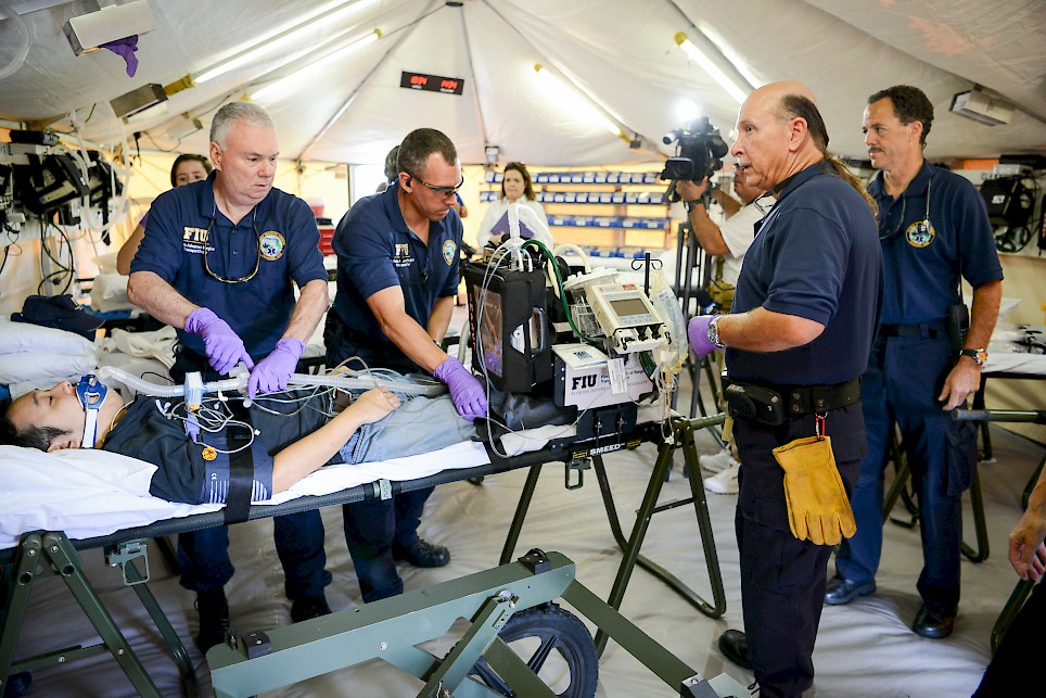 FIU-FAST Team members inside their critical care tent, simulating patient packaging of a critical patient for helicopter transport in Miami, Florida (Source: FIU Media Relations, 29 April 2016).